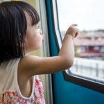 small child looking outside the window of a bus