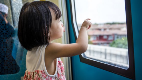 small girl looking outside the window on public transportation