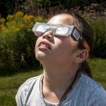 Girl using solar eclipse glasses