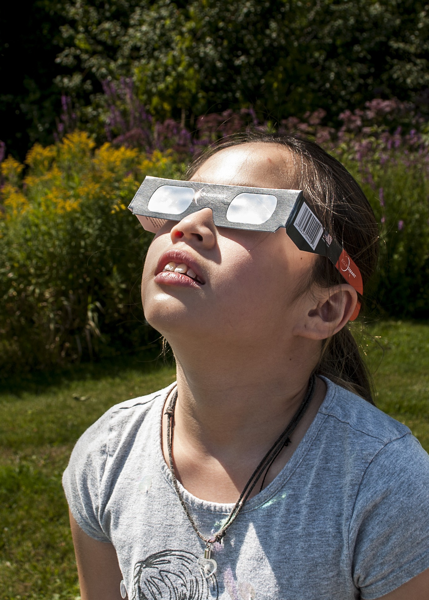 young girl looking at the solar eclipse with protective eye wear