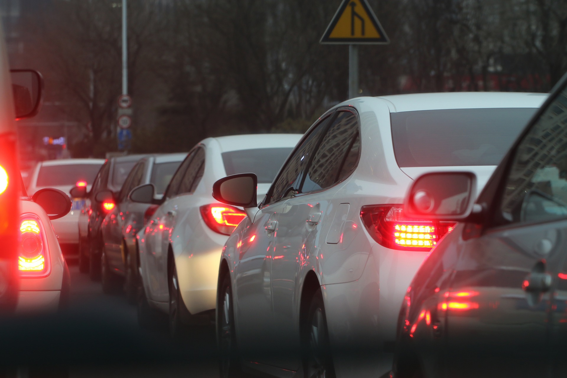 A line of cars sitting in traffic with their brake lights on